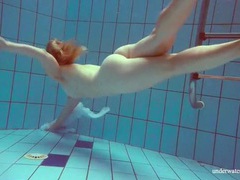 TubeHardcore presents: Redhead goes for a nude swim in the pool